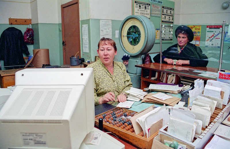 Office staff working with laptops in a bright meeting room