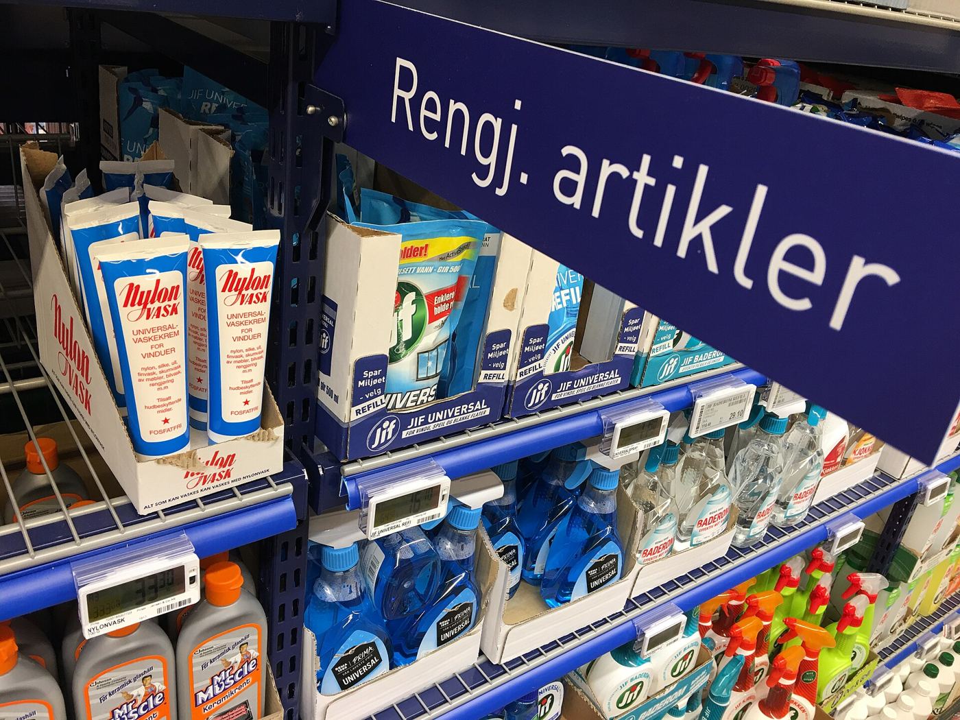 A shopper facing long supermarket shelves of products
