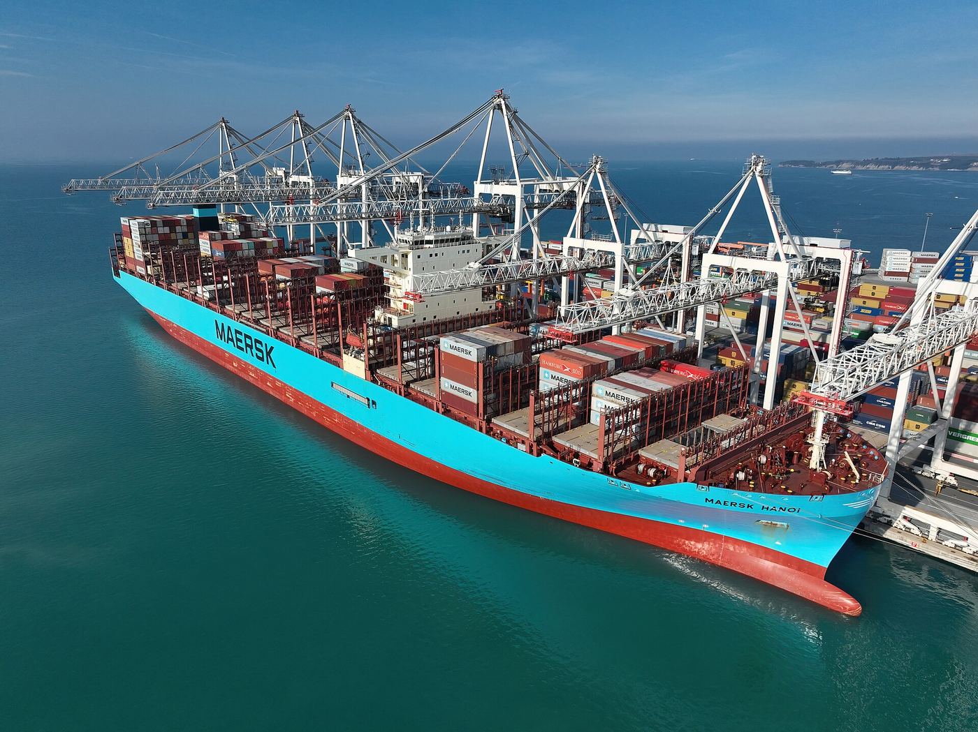 Large container ship docked at a busy commercial port