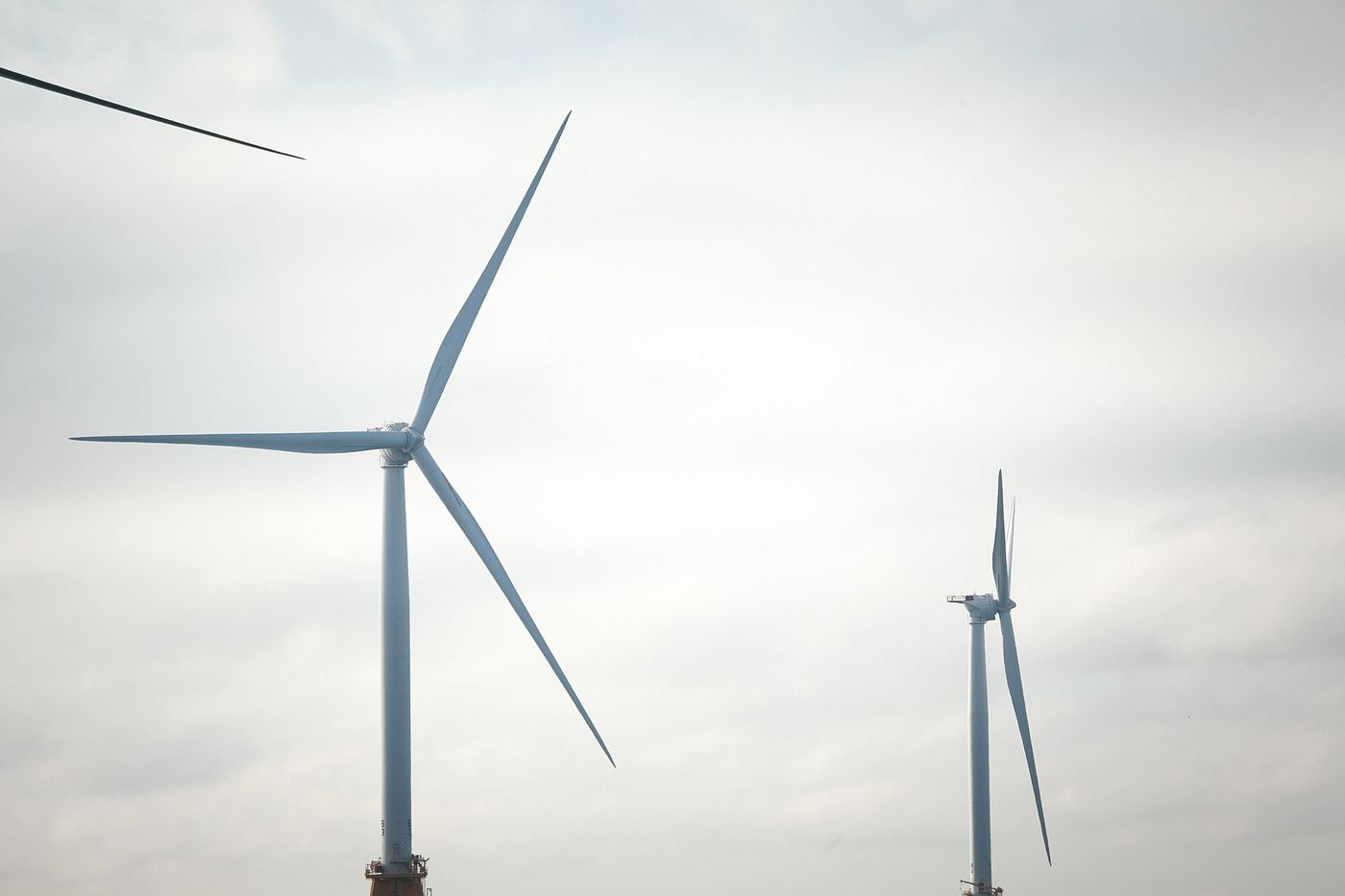 Wind turbines standing in open countryside under a cloudy sky